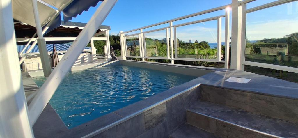 una piscina en una casa con ventanas en Gîtes Capra Pomme Surette piscine et spa, en Bouillante