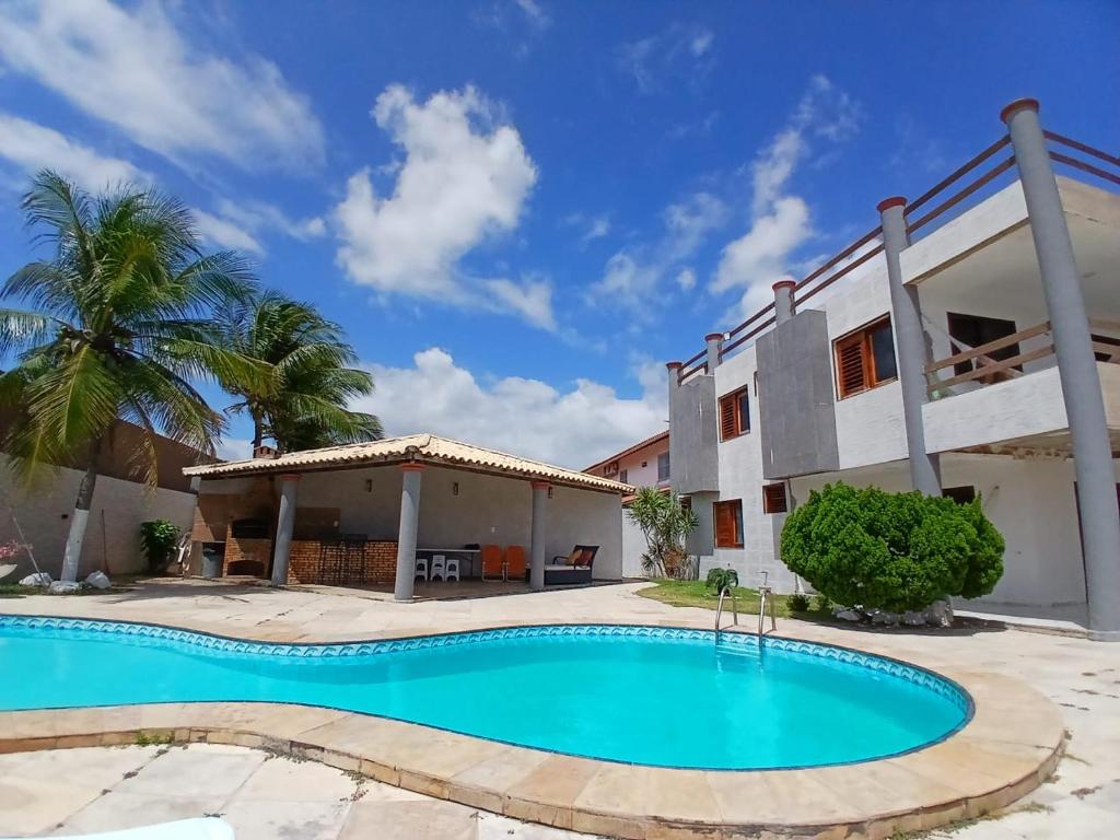 eine Villa mit Swimmingpool und ein Haus in der Unterkunft Vila Nordestina in Caucaia