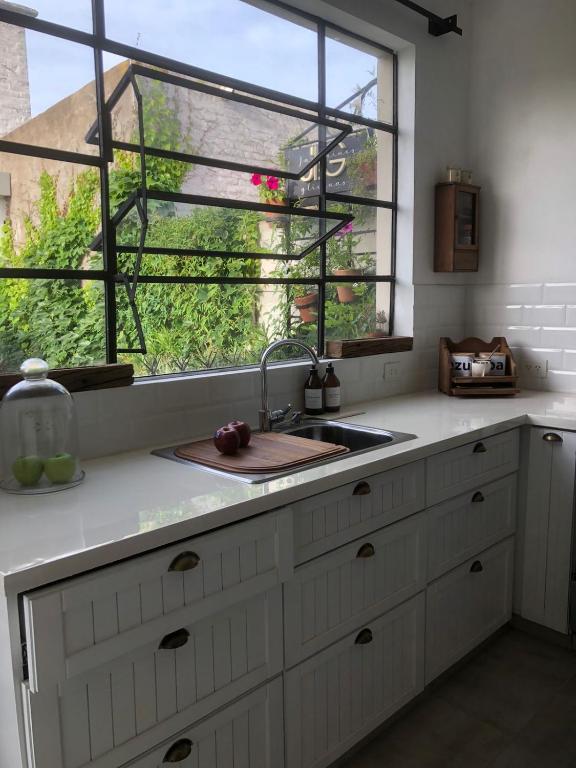 une cuisine avec un évier et une fenêtre dans l'établissement Entre Jazmines & Glicinas, à Lobos