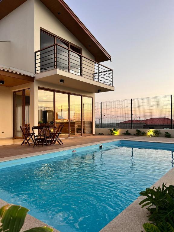 a house with a swimming pool in front of a house at Casa Vista Serrana in São Pedro