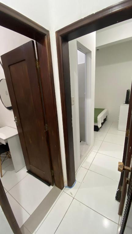 a wooden door in a room with a mirror at Suíte Standard Privado in Vitória