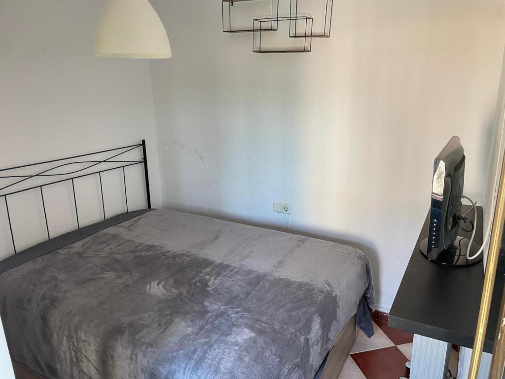 une chambre avec un lit et une télévision dans l'établissement Zahara Lovers, à Zahara de la Sierra