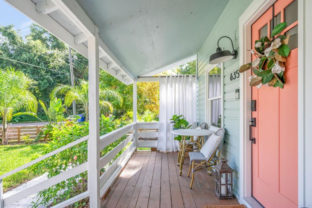eine Veranda mit einem Tisch und Stühlen auf einem Haus in der Unterkunft Casa Madeore Luxury Bungalow in St. Augustine