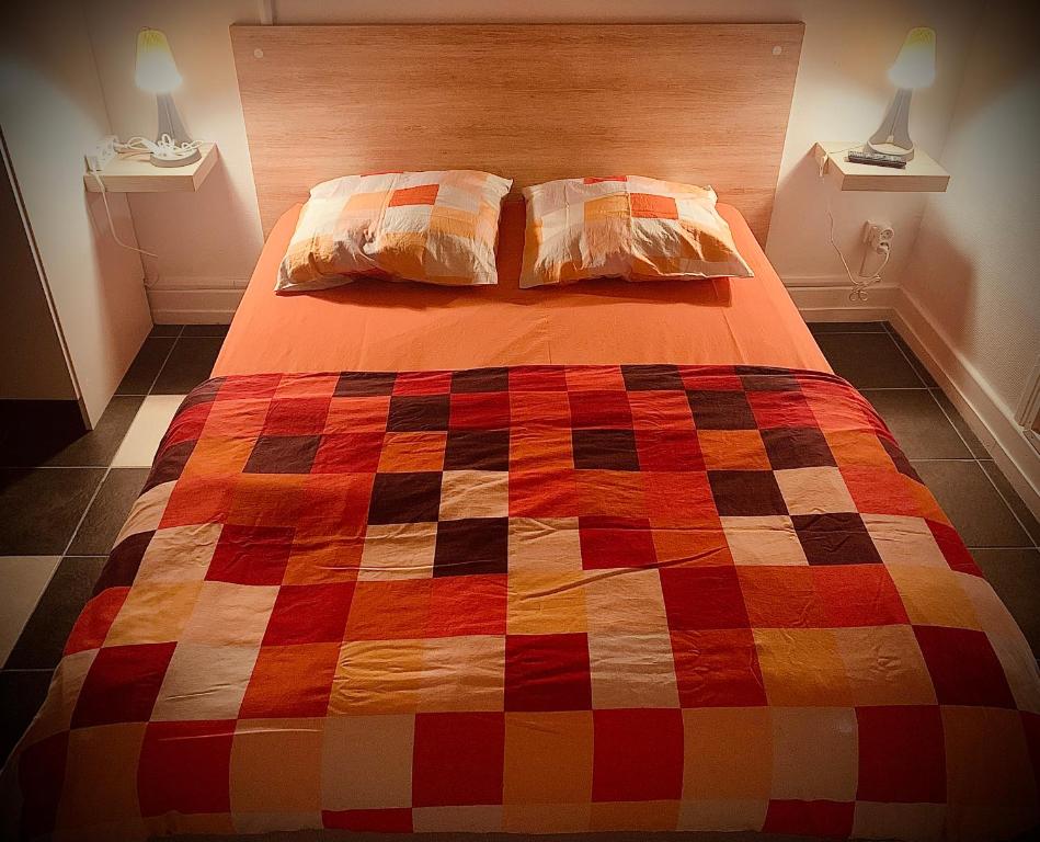 布隆302 Bron galerie lafayette的一张床上,床上有五颜六色的被子