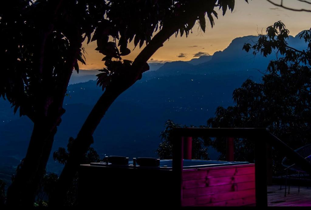 Una vista de las montañas desde un resort por la noche. en Glamping Entre Mangos, en La Mesa