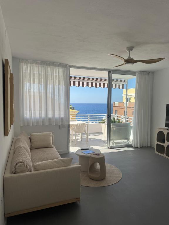 a living room with a couch and a view of the ocean at Ático A-mar in Puerto Naos