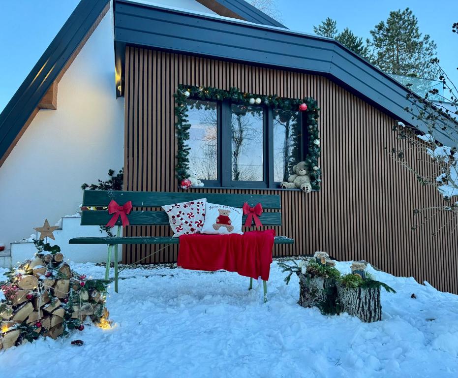 a house covered in snow with a table in front of it at Kuća za odmor Šumska vila in Duga Resa