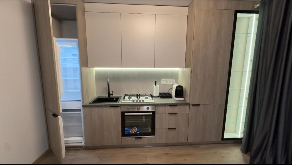 een keuken met witte kasten en een kookplaat oven bij Sunset apart in Kremenets