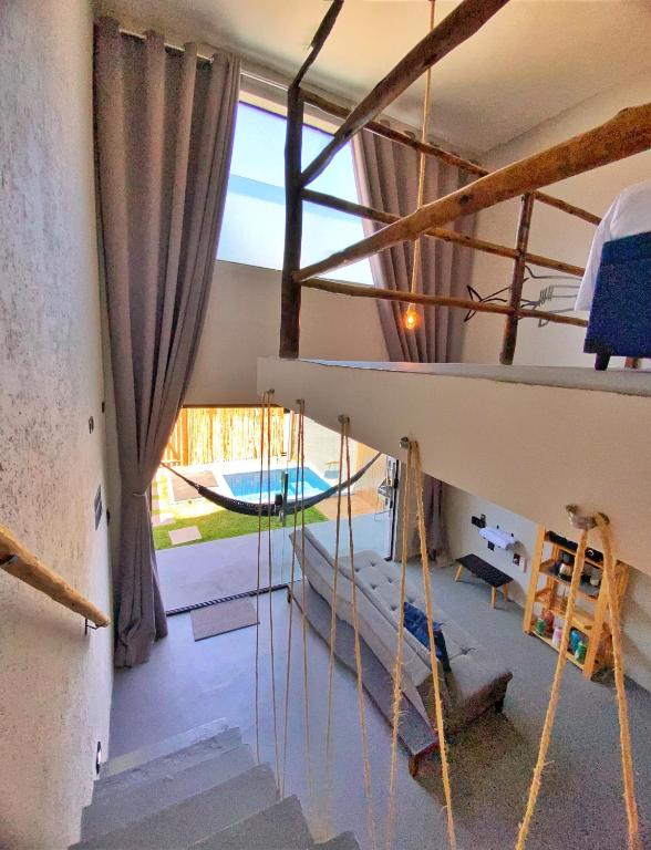 a room with stairs and a room with a swimming pool at LOFT Mar 101 - Com Piscina Privativa a Poucos Passos de Vilas Gastronômicas Polo de Artesanato e Associação Peixe-boi in Pôrto de Pedras