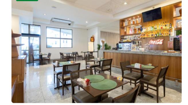 ein Restaurant mit Tischen und Stühlen und eine Bar in der Unterkunft Beira Mar Boa Viagem Beach Class Executive in Recife
