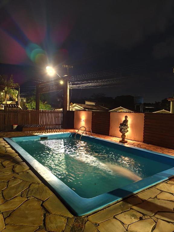 a small swimming pool at night with a light at Pousada do Betão in Guarda do Embaú