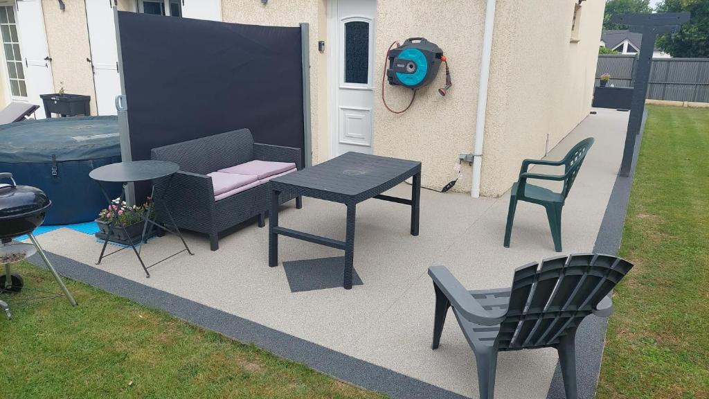 d'une terrasse avec une table, des chaises, une table et des chaises. dans l'établissement Chambre Magnolias, à Saint-Sauveur-dʼÉmalleville