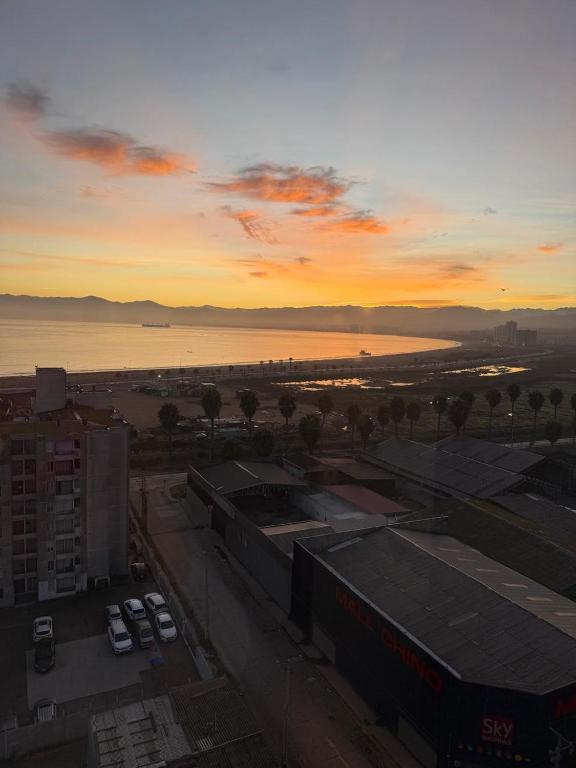 a sunset over a city with cars parked in a parking lot at alojamiento en coquimbo in Coquimbo