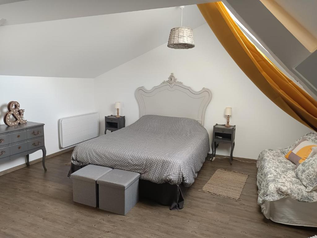 - une chambre avec un lit, deux tables et une chaise dans l'établissement chambre d'hôte Léonie, à Saint-Riquier
