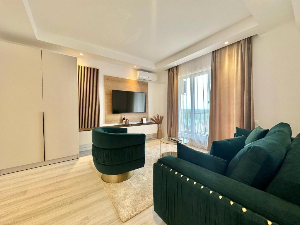 Una sala de estar con un sofá verde y un televisor. en Aurora Premium Cosmopolis, en Tunarii