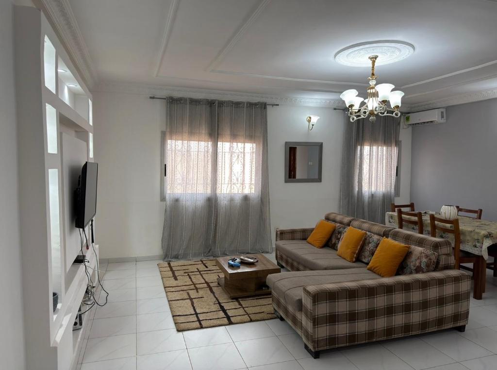 a living room with a couch and a tv at Le nid douillet in Yaoundé