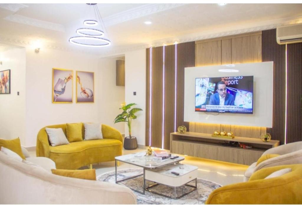 a living room with a couch and a tv at Epic Apartment in Abuja