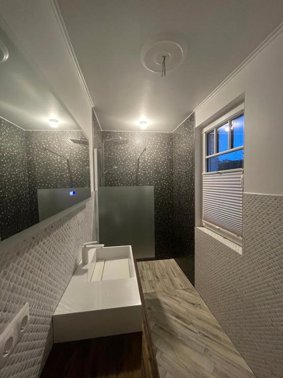 een badkamer met een witte wastafel en een raam bij Haus Maria am Meer in Göhren