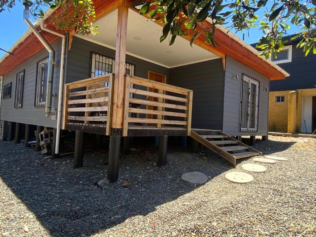 a tiny house with a porch and a staircase to it at Casa Pichilemu in Pichilemu