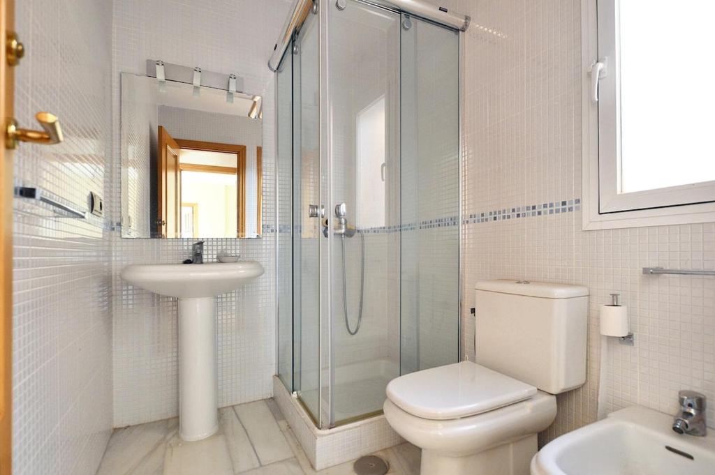 een badkamer met een douche, een toilet en een wastafel bij Apartamento vital centrico in Lanjarón