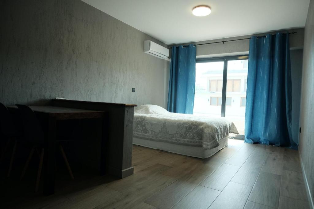 Un dormitorio con una cama y un escritorio y una ventana. en Modern Studio Near Lazaretto Beach with a View of Monte Cara, en Lazareto