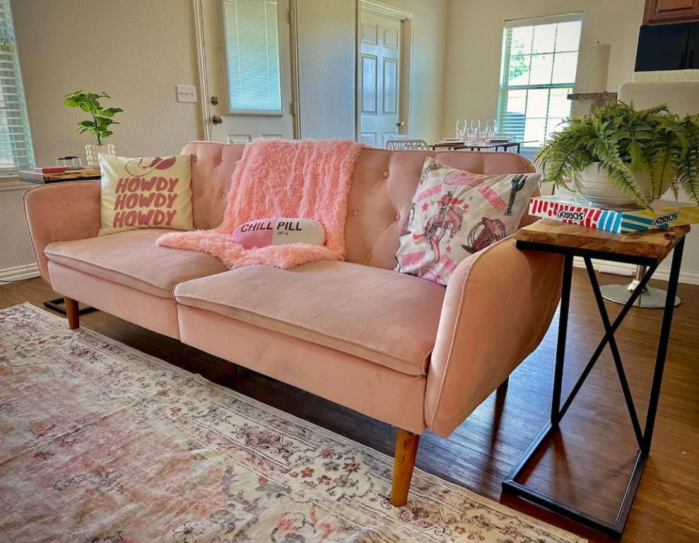 CaleraFuN FABulous KINGbed by ChoctawCasino LakeTexoma的客厅配有一张粉红色的沙发,配有一张桌子