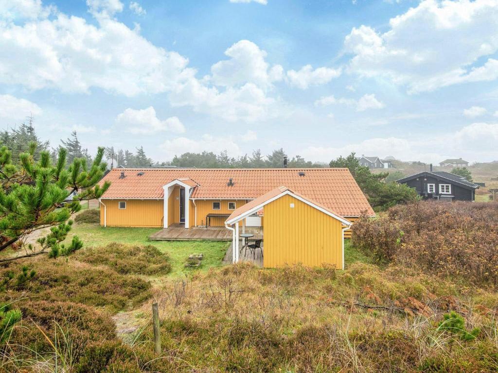 a yellow house in the middle of a field at Bright Beach House with Sauna - By Traum Ferienwohnungen in Vejers Strand