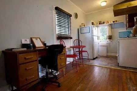 a room with a desk and a kitchen with a refrigerator at Cozy Modern Studio - Heart of Lafayette in Lafayette