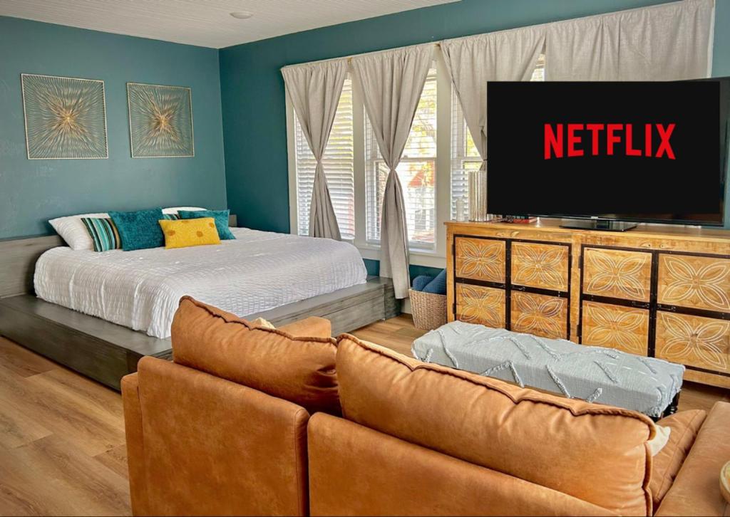 ein Schlafzimmer mit einem Bett und einer Couch und einem Fernseher in der Unterkunft Gorgeous loft downtownSherman washer dryer WiFi in Sherman