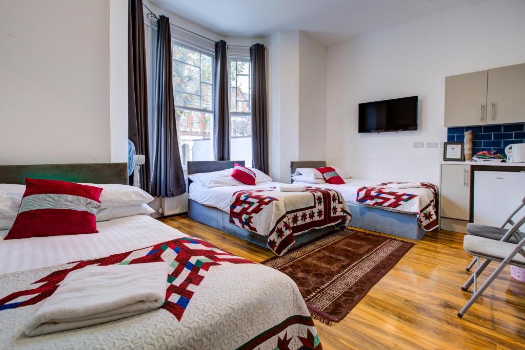 um quarto de hotel com duas camas e uma TV em London Residence Hotel em Londres