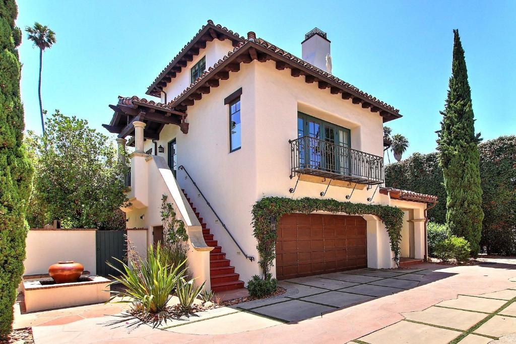a white house with a gate and a garage at Casa Playa in Santa Barbara