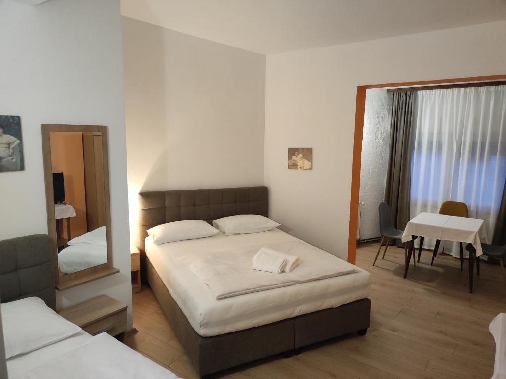 a bedroom with a bed and a mirror and a table at Rooms San in Velika Gorica