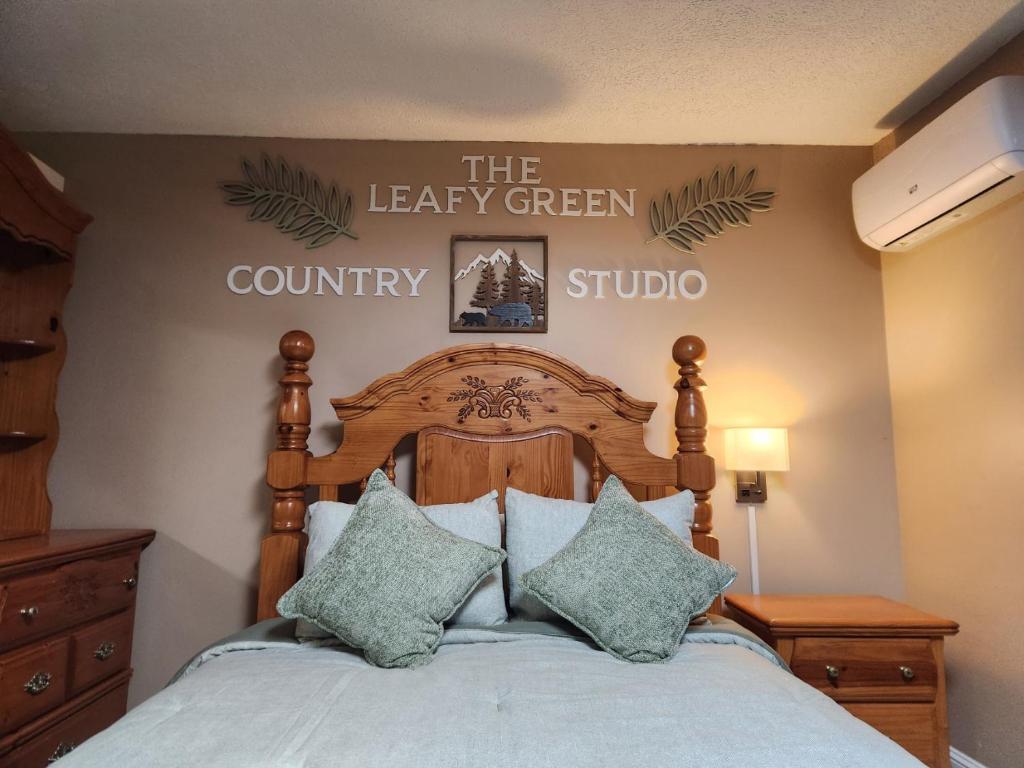 ein Schlafzimmer mit einem Bett und einem Schild an der Wand in der Unterkunft The Leafy Green Country Studio in Mount Vernon