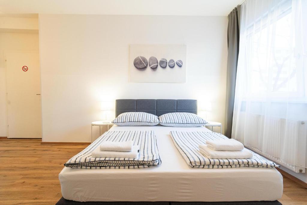 una cama blanca grande en una habitación con ventana en Alps Studio, en Innsbruck