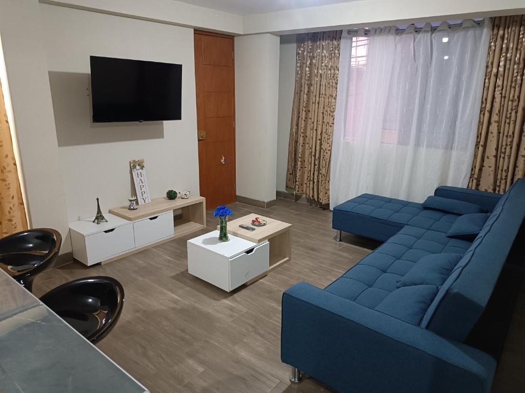Una sala de estar con dos sofás azules y un televisor. en DEPPIu, en Piura