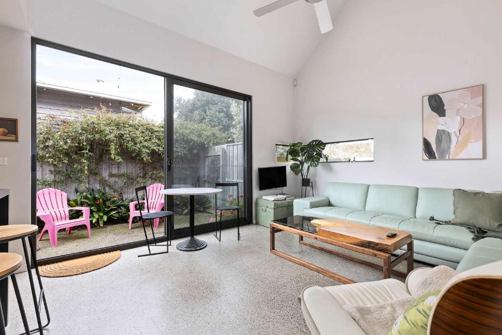 ein Wohnzimmer mit Sofa und Tisch in der Unterkunft Spacious 1-Bed Townhouse in Norlane in Norlane