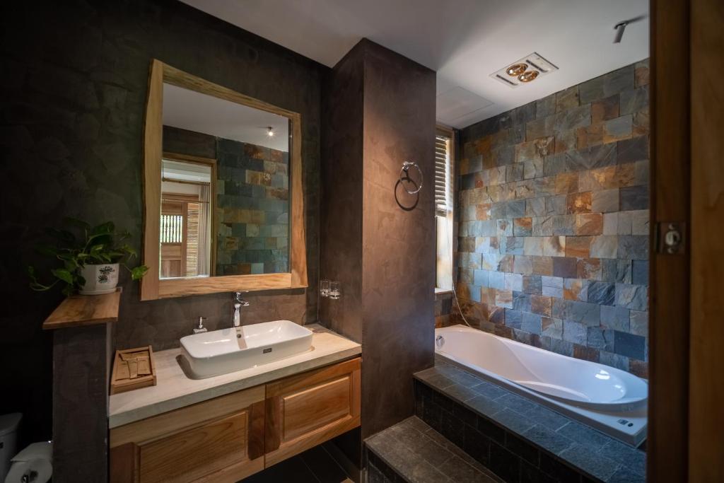 Un baño con bañera, lavabo y bañera. en Vanlong garden, en Kon Rung (1)