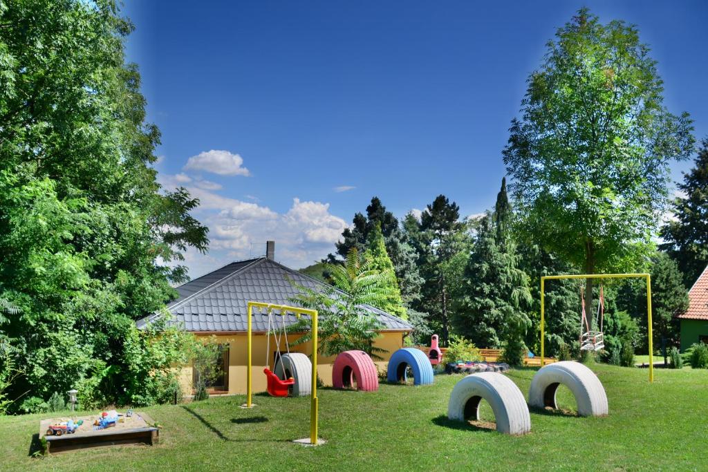 Areal Hradišek في Klobouky u Brna: ملعب في حديقة مع معدات اللعب الملونة
