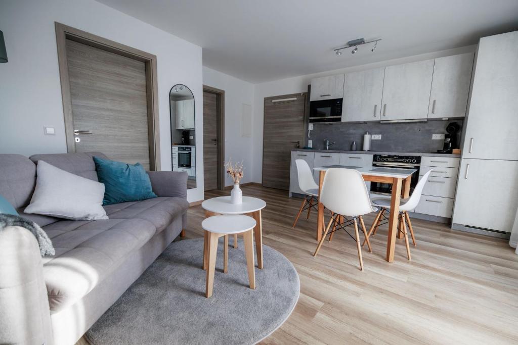 ein Wohnzimmer mit Sofa, Tisch und Stühlen in der Unterkunft Stylishes Premium Apartment in Sinsheim
