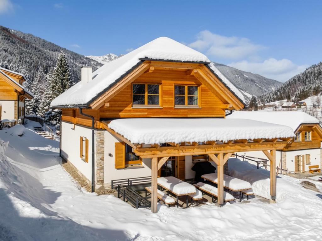 a log cabin with snow on the roof at Ferienhaus Erna in Donnersbachwald