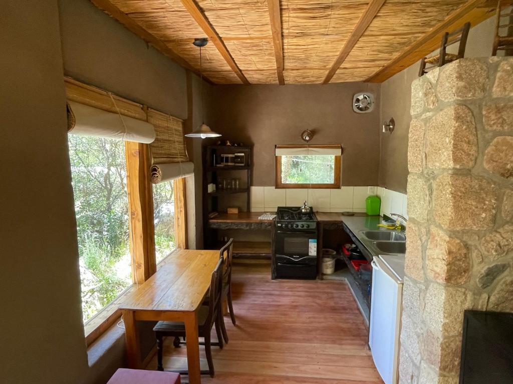 a kitchen with a wooden table and a dining room at Descansa al pie del champaqui escuchando el arroyo in San Javier