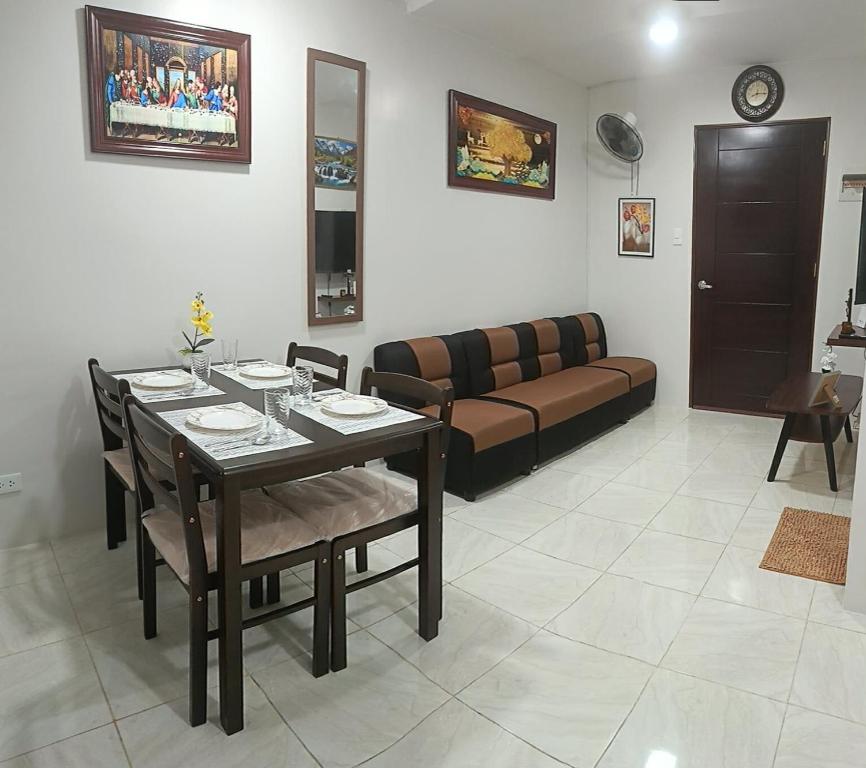 una sala de estar con una mesa y un sofá en SKL Staycation Hub, en Mandaue