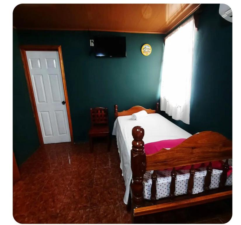 une chambre avec un lit en bois et une fenêtre dans l'établissement Hostal Fernánda, à Corn Island