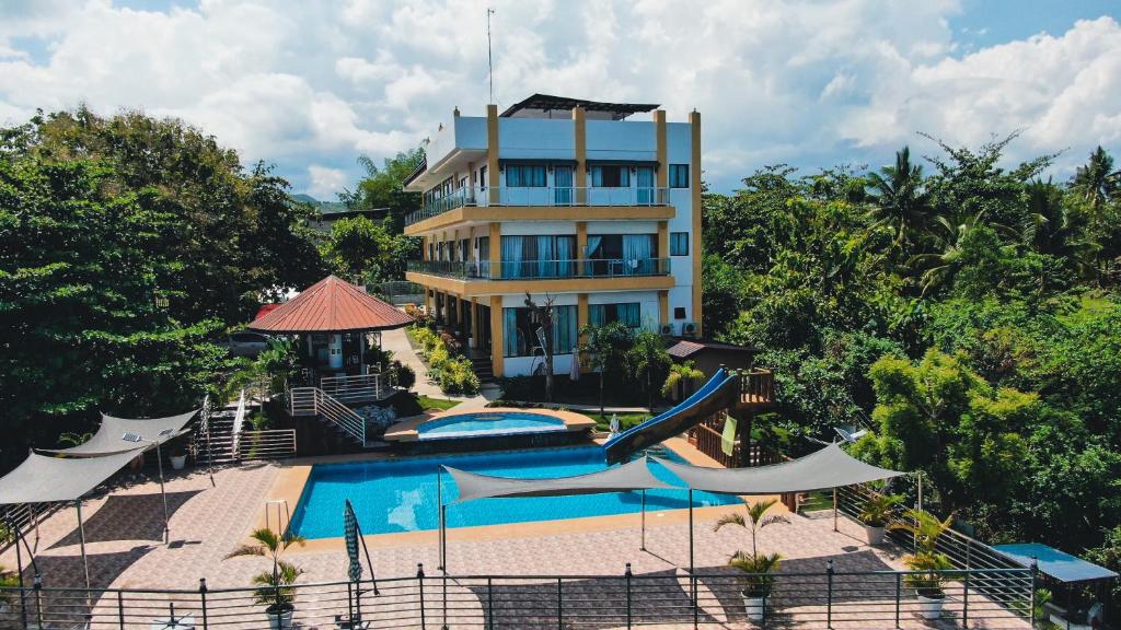 a hotel with a swimming pool and a building at Sacaan Tropical Breeze Resort in Sogod