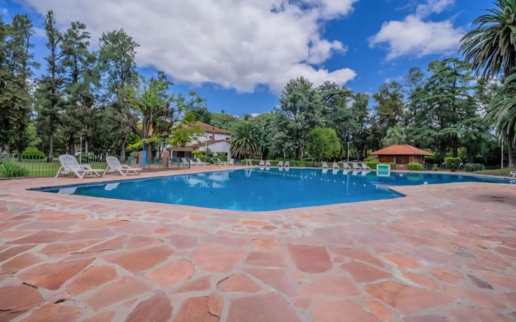 a large swimming pool with chairs and trees at Allá en el sur Canning in Ezeiza