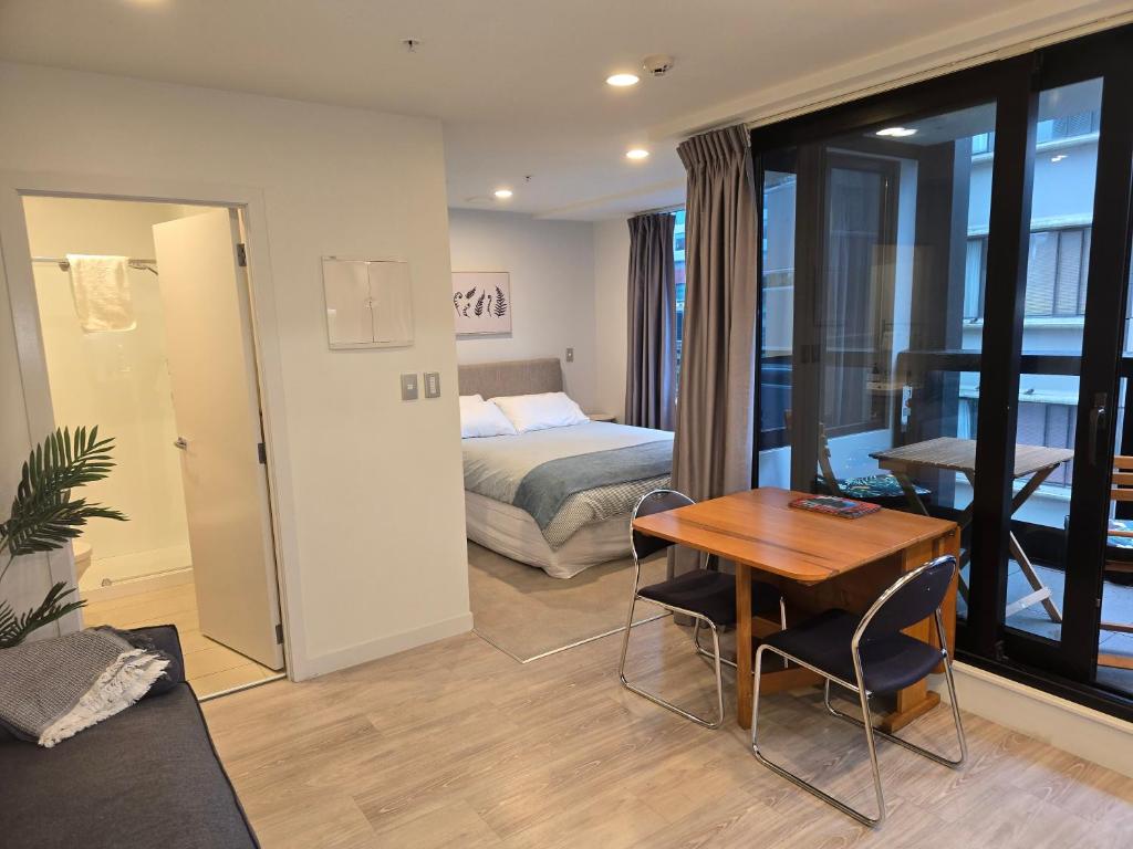 a hotel room with a bed and a table and a bedroom at Central City Prime-next to SKY in Auckland