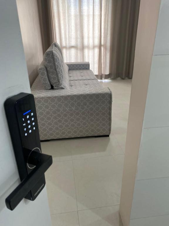1 dormitorio con 1 cama en una habitación con espejo en Apto 2 qtos perto do Aeroporto, próximo ao CRER, en Goiânia