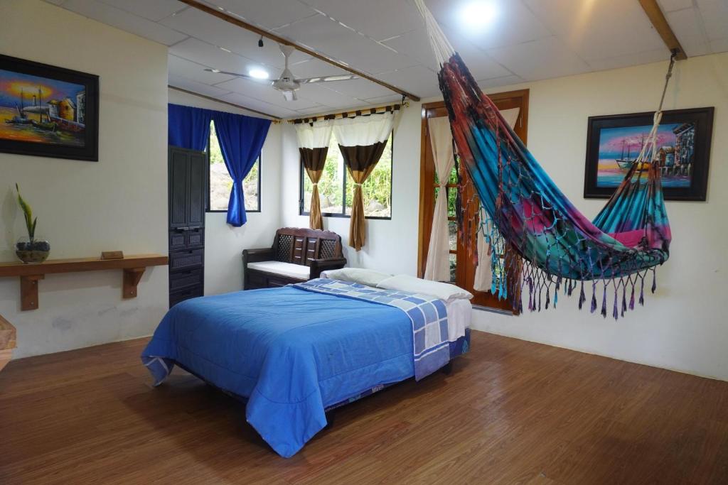 ein Schlafzimmer mit einem Bett mit einer hängenden Hängematte in der Unterkunft Shark House in Bellavista