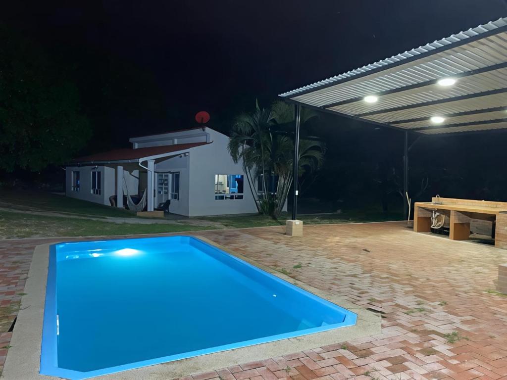 a blue swimming pool in a backyard at night at Finca El Balmoral in Tocaima