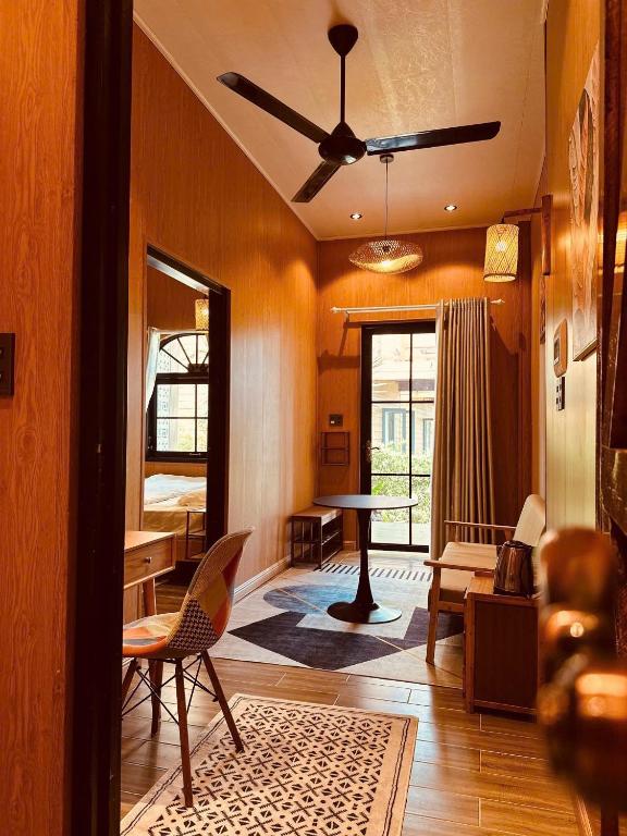 a living room with a ceiling fan and a table at Giăng's House Farmstay & Glamping in Bảo Lộc